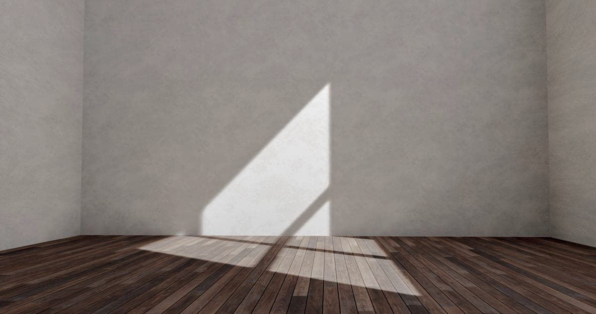 Bare wooden floorboards catching low afternoon light in an apartment room